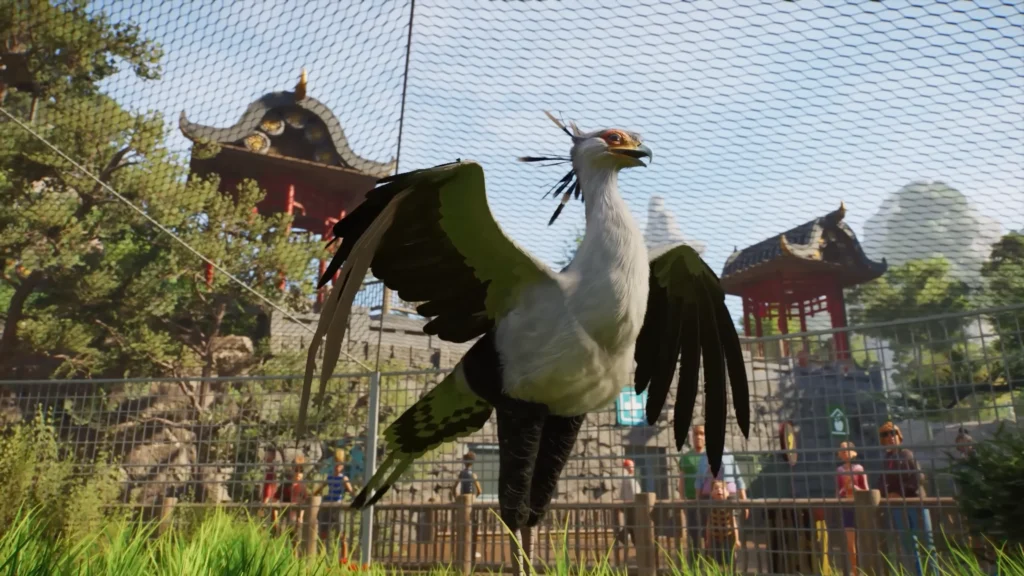 Secretarybird spreading its wings beneath a mesh aviary roof in Planet Zoo 2, with zoo visitors in the background